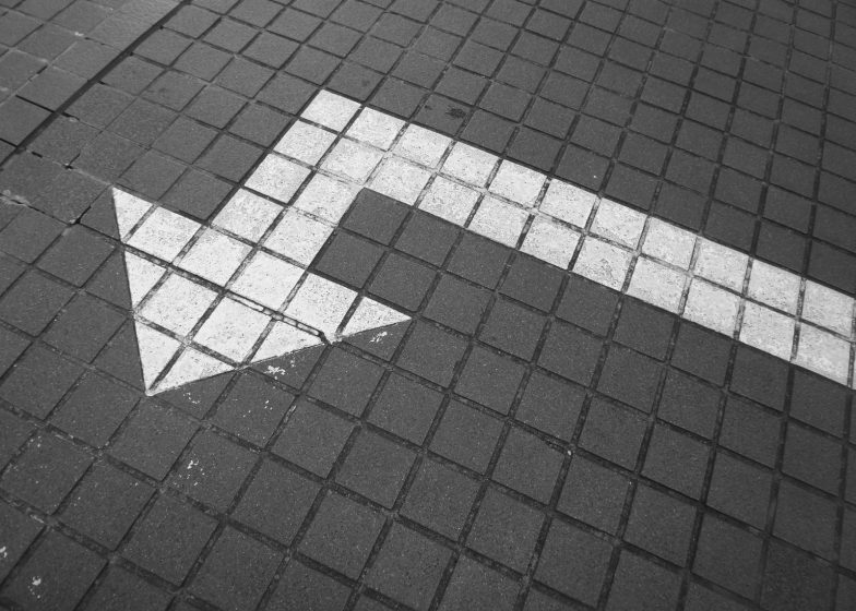 white arrow on bricked pavement